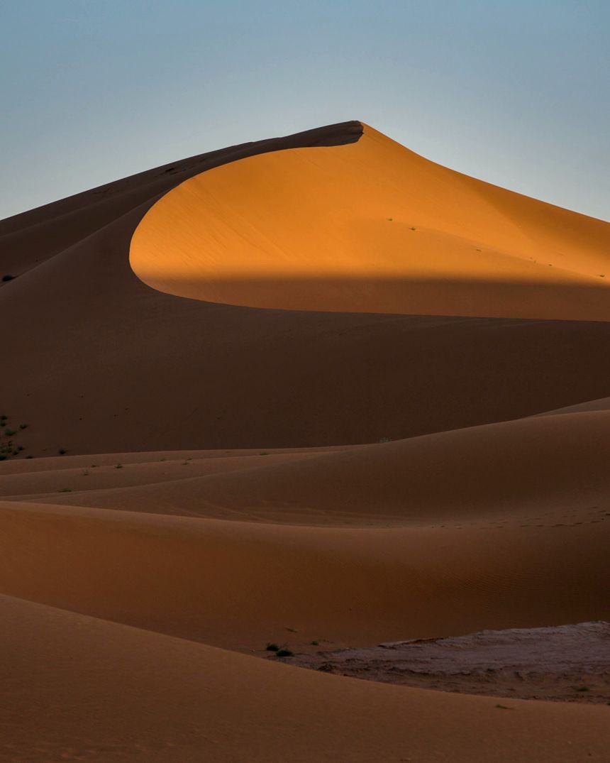 Dunas de areia iluminadas pelo sol no deserto