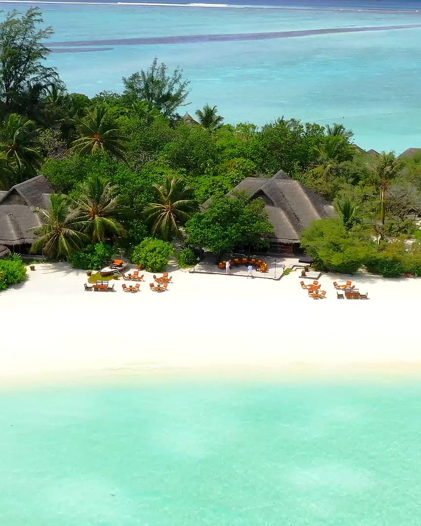 Ilha tropical com águas turquesa e bangalôs à beira-mar